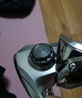 Close-up of aluminum alloy fishing reel cap replacement for spinning reels, precision screw nut accessory kit, installed view.