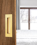 6 Inch Recessed Finger Pulls For Pocket Doors And Sliding Doors in brushed gold stainless steel, installed on wooden door
