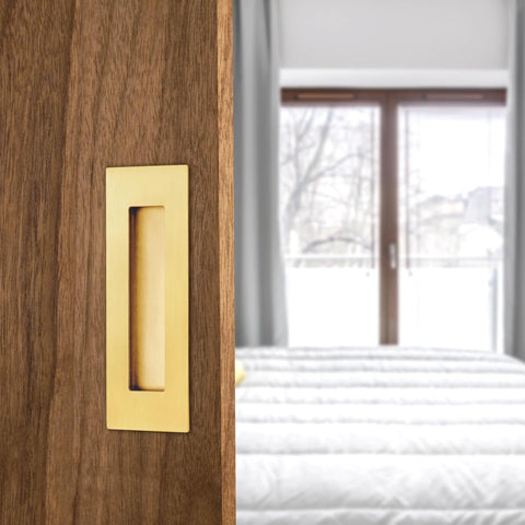 6 Inch Recessed Finger Pulls For Pocket Doors And Sliding Doors in brushed gold stainless steel, installed on wooden door