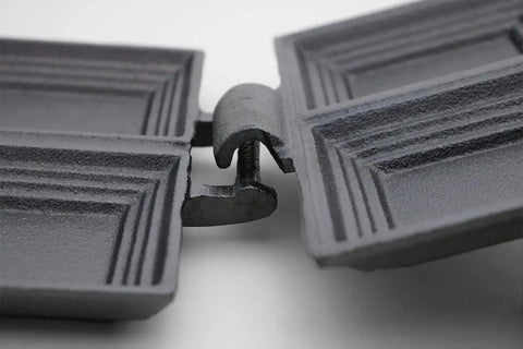Close-up of Cast Iron Double Camp Cooker Set With Two Cooking Surfaces Preseasoned For Instant Use Perfect For Camping Grillin Sandwiches And Pies Durable Outdoor Cookware Pack Of 2 hinge detail showing textured surfaces.