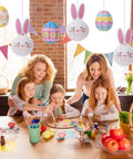 Family painting Easter eggs under 9 Piece Easter Paper Lantern Set With Bunny And Egg Designs, Reusable 10 Inch Pastel Hanging Lanterns