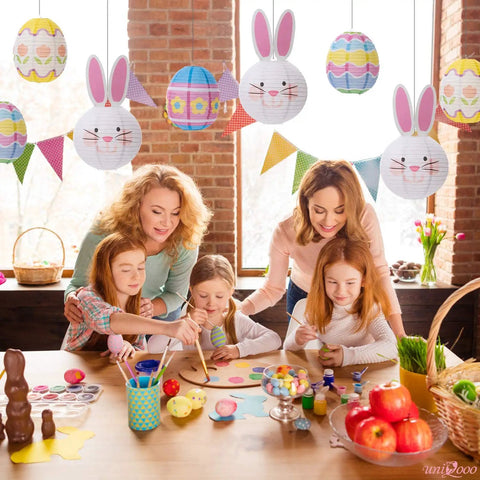 Family painting Easter eggs under 9 Piece Easter Paper Lantern Set With Bunny And Egg Designs, Reusable 10 Inch Pastel Hanging Lanterns