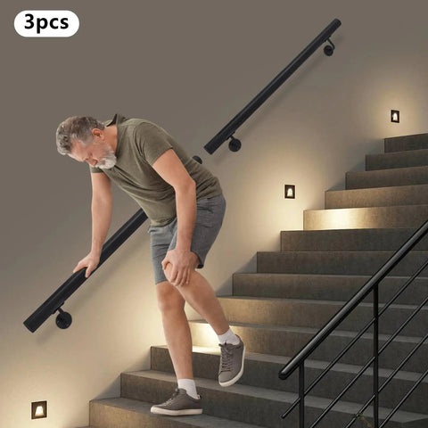 A man using a Heavy Duty Black Stair Handrail Crafted From Premium Stainless Steel Wall Mounted for safe stair navigation.