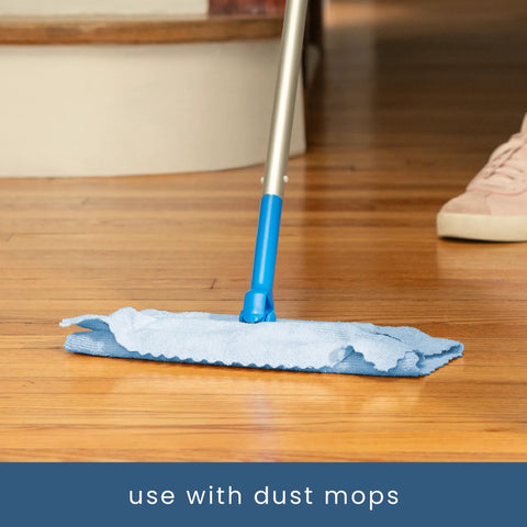 Front view of blue microfiber mop with a metal handle and blue pad on a wooden floor.