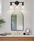 Three Light Matte Black Bathroom Vanity Light Fixtures With Clear Glass Shades above a modern mirror in a stylish bathroom.