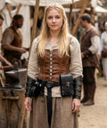 Person in a medieval setting wearing Badass Renaissance Belt Pouch Set With Detachable Corset Strap Soft Leather Bracers.