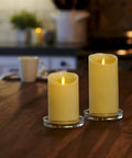 Two Flameless LED Ivory Pillar Candles With Real Wax Look on a Table, Battery Powered, Realistic Moving Flame, Indoor Lighting