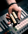 Person holding Spark Link XLR Wireless System For Dynamic Microphones Pro Grade Studio Audio with keyboard background.