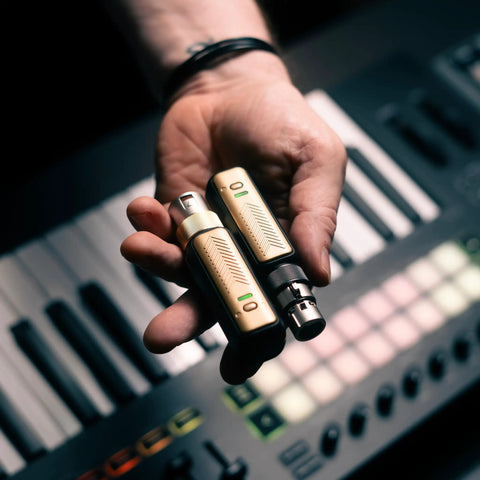 Person holding Spark Link XLR Wireless System For Dynamic Microphones Pro Grade Studio Audio with keyboard background.