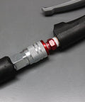 ColorFit M-Style Red 1/4 Inch NPT Coupler And Plug Kit 3-Piece Set connected to air tool on gray surface.