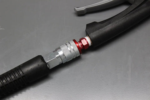 ColorFit M-Style Red 1/4 Inch NPT Coupler And Plug Kit 3-Piece Set connected to air tool on gray surface.