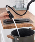 Person using Colin Black Kitchen Faucet With Pull Down Sprayer And Magnetic Docking 20in hose to fill pot on wood countertop.