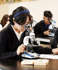 Student using Student Biological Compound Microscope With Cordless LED Illumination in classroom setting