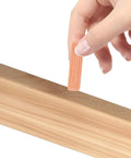 Hand holding a wooden dowel pin next to a wood surface, featuring Wooden Dowel Pins M8x30mm For Furniture Assembly Solid Round Dowels In Beige