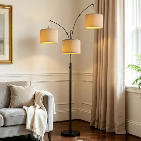 Fully Dimmable Three Light Arc Floor Lamp With Beige Shades in modern living room with couch and curtains