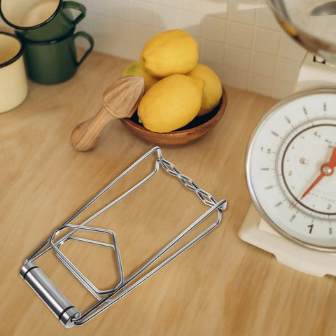 Heavy Duty No Burn Bowl Gripper Slick Stainless Steel Heat Resistant Pot Tongs Non Slip Dish Lifter on a wooden counter with lemons.