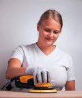 Top Tier 6 Inch Random Orbital Sander Featuring A Smooth Brushless Motor And Effective Dust Extraction Built For Rough Woodshop Jobs Drywall Sanding And Auto Detailing Comes With A Sturdy Zippered Case in use on wood surface by female user.