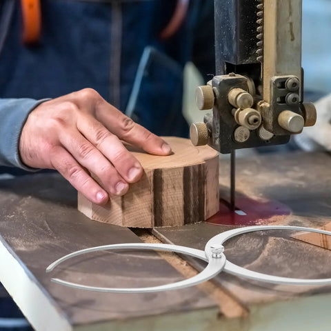Two 11-inch stainless steel double-ended bowl calipers for woodturning on a workbench.