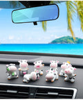 8-piece cow dashboard ornament set for car interior; small white plastic cows with black spots arranged on the dashboard.
