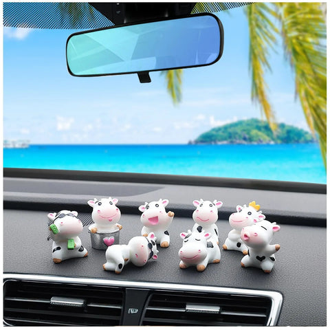 8-piece cow dashboard ornament set for car interior; small white plastic cows with black spots arranged on the dashboard.