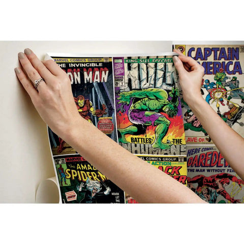 Hands applying Marvel Comics Peel And Stick Wallpaper Mural For Living Room Or Kids Room Ten And A Half Feet By Six Feet Easy To Apply Removable Adhesive Backing No Paste Wall Decor featuring Hulk and Iron Man covers.