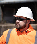 Construction worker wearing Tinted Safety Glasses 12 Pack ANSI Z87 Plus UV Eye Protection for outdoor work and industrial safety.