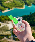 Directional Thumb Compass, MultiUse Pocket Navigation Tool for Hiking and Backpacking held over a scenic landscape