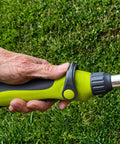 Close-up of hand holding 15 Inch Watering Wand With 8 Spray Patterns And Thumb Control for Reaching Hanging Baskets and Deep Beds.