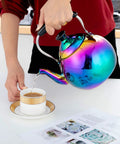 Induction Compatible Stovetop Tea Kettle Stainless Steel Whistling Tea Kettle Rainbow Iridescent Mirror Finish 2 Quart For Gas Stove Top Fast Boiling Water Modern Colorful Teakettle pouring tea