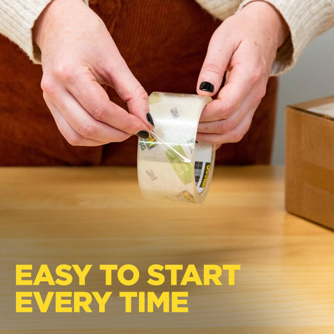 Hands using Smooth Operator Clear Shipping Packing Tape With Heavy Duty Dispenser for easy box sealing.