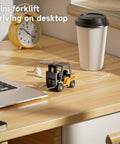 One Sixty Fourth Scale Alloy RC Forklift Toy With Lights And Sounds on a desk near a laptop and coffee cup