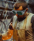 Man wearing Badass Impact Resistant Welding Safety Goggles 3 Piece Set In Black Gray Shades while welding.