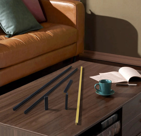 Black Tilted Aluminum Cabinet Handles 12 Pack 5 Inch 128mm on a coffee table next to a cup and book
