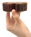 Hand holding a piece of a Twenty Piece Pro Grade Abrasive Flap Wheel Sander Set With Eight Flap Wheel Sizes And Two Cone Shapes, 80 Grit, One Quarter Inch Shank, Drill Ready For Metal And Wood, Rust Removal Made Easy showcasing the 80 grit surface.