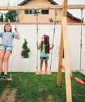 Children using swings on wooden playset with Silent Ball Bearing Swing Hangers, Heavy Duty 360 Degree Rotating Swing Swivel Hooks.