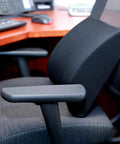 Premium Lumbar Support Pillow For Chair With Ergonomic Contoured Foam Insert designed to ease lower back pain on black office chair.
