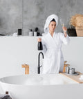 Woman in bathrobe holding champagne, beside freestanding bathtub and modern decor, near 10 Pack Slim GFCI Outlets 15A 125V With Self Test LED Indicator