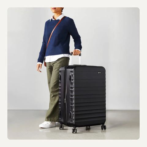 Front view of Amazon Basics 30-inch black hardside luggage with four multi-directional wheels