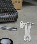 Heavy Duty Soft Close Lift Hinges For Cabinet Doors AGFELO 2 Pack Zinc Alloy placed on a workshop floor with tools nearby.