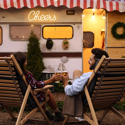 Couple toasting under Cheers Neon Sign For Home Bar Wall Decor Battery Or USB Powered Bright Warm White Light on caravan