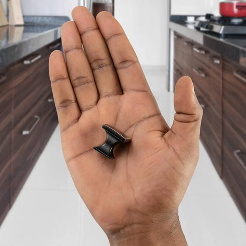 Close-up of hand holding Ten Pack Small Oil Rubbed Bronze Cabinet Knobs Square Single Hole Pulls for Cabinets Drawers