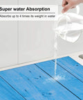 Pouring water onto Ultra Absorbent Wood Grain Dish Drying Mat For Kitchen Counter With Microfiber Surface, Machine Washable, 16 by 18 inches.