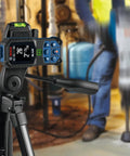 Blaze Green Beam Laser Distance Measure With 165 Foot Range And One Sixteenth Inch Accuracy on tripod in workshop