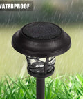 Close-up of a Six Pack Solar Pathway Light Outdoor Waterproof Garden Light with metal and glass under rain, on grass.