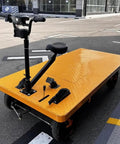 Huge Heavy Duty Electric Platform Truck Cart That Folds Like A Dream For Moving Groceries And Warehouse Gear With Slip Resistant Surface Holding Up To 2K Lbs, bright yellow with a seated handle.