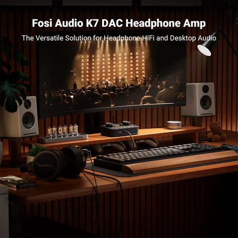 K7 DAC Headphone Amplifier for desktop gaming and HiFi music setup on a wooden desk with speakers and keyboard in a home environment.