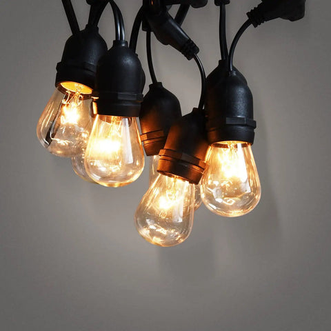 Close-up of 52 Ft Outdoor String Lights With 30 Incandescent Bulbs UL Listed Commercial Quality Edison Patio Cafe Market Lights glowing.