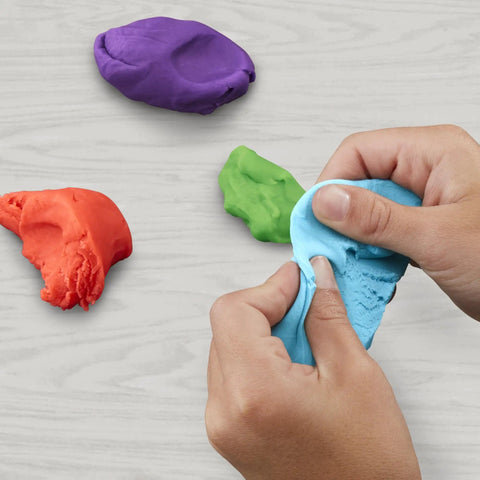 Hands kneading blue mini modeling compound with vibrant orange, purple, and green clays for creative play activities.