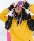Person wearing Four Pack Ski Glove Leashes Made From Premium Nylon With Metal Button Keep Your Gloves On The Go During Mountaineering Skiing Snowboarding And Other Outdoor Sports Grey, attached to black gloves and yellow jacket.