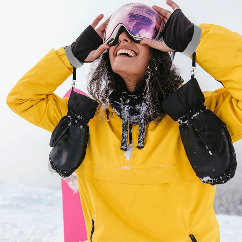 Person wearing Four Pack Ski Glove Leashes Made From Premium Nylon With Metal Button Keep Your Gloves On The Go During Mountaineering Skiing Snowboarding And Other Outdoor Sports Grey, attached to black gloves and yellow jacket.
